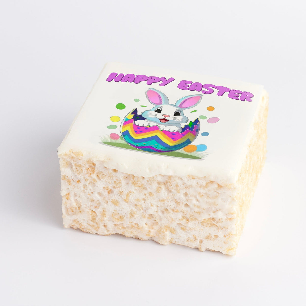 The Crispery Easter Bunny Crispycake, current design: marshmallow crispy rice square with a printed cartoon bunny popping out of a striped Easter egg under pink Happy Easter lettering