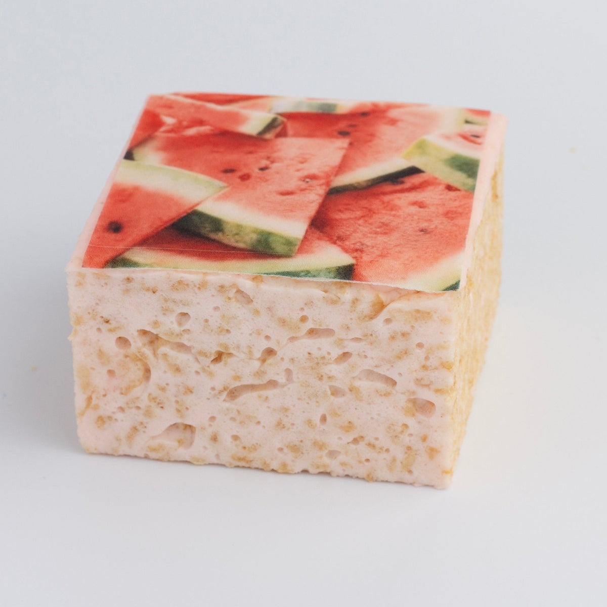 The Crispery Tropical Fruit Watermelon Crispycake on a grey background, with printed watermelon wedges on top