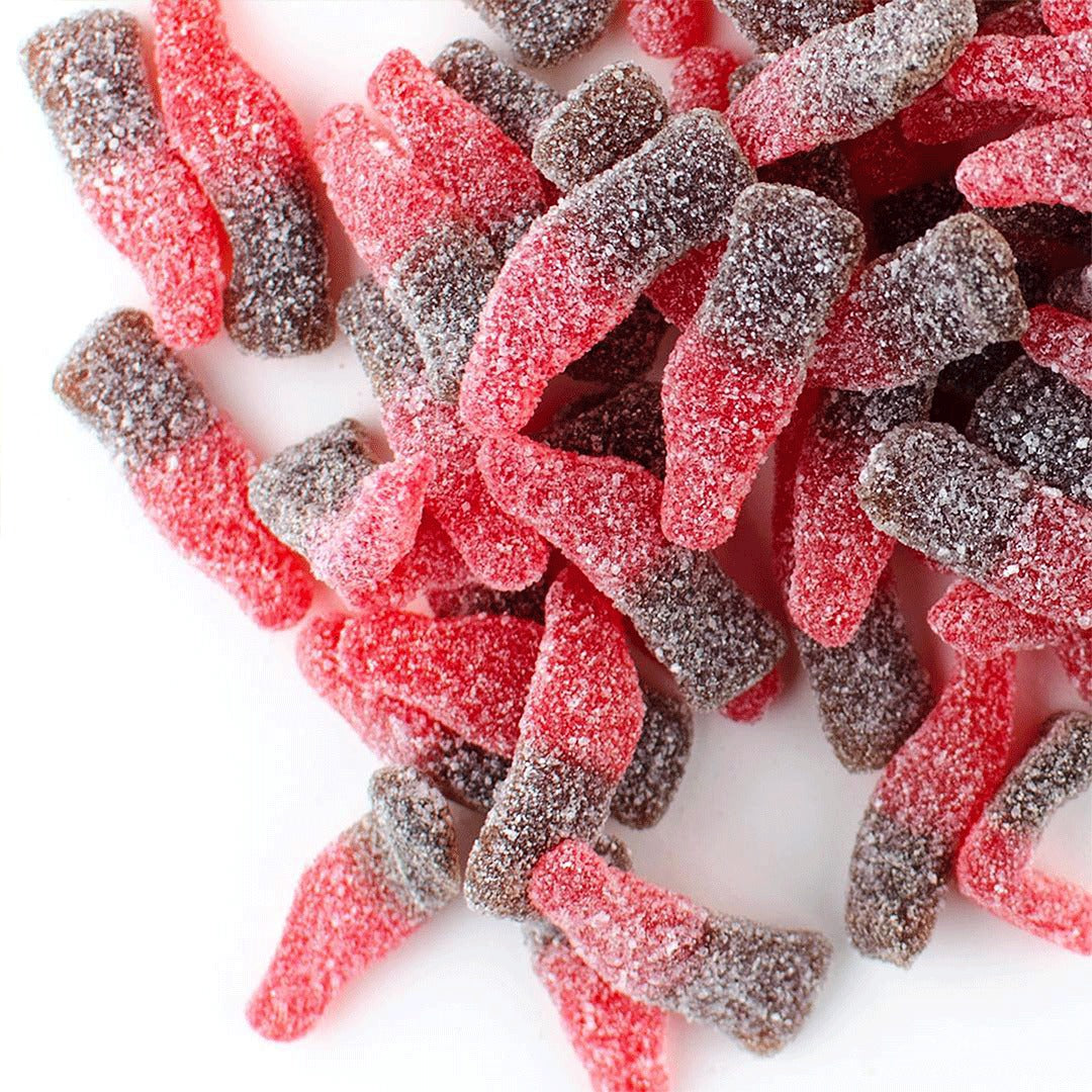 Close-up of two-tone red and brown sour sugar-coated cherry cola gummy bottles