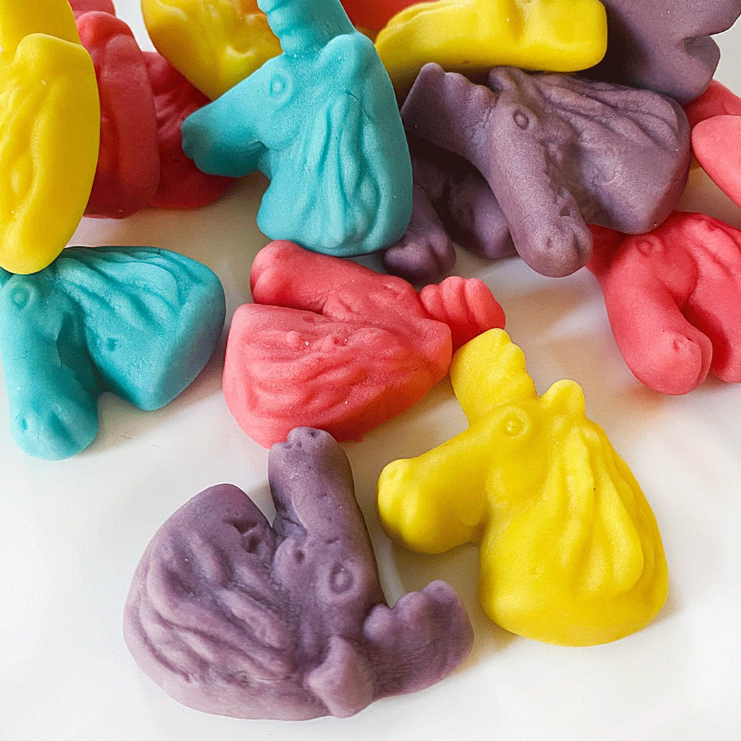Close-up of Gummi Unicorns pieces in yellow, blue, pink and purple showing the molded unicorn-head shape