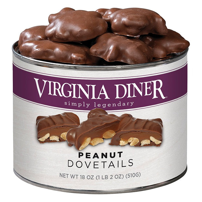 Virginia Diner Peanut Dovetails 18 oz tin, purple label band with a cut cluster showing peanuts and caramel, heaped with chocolate-covered clusters; label reads Net Wt 18 oz (1 lb 2 oz) (510 g)