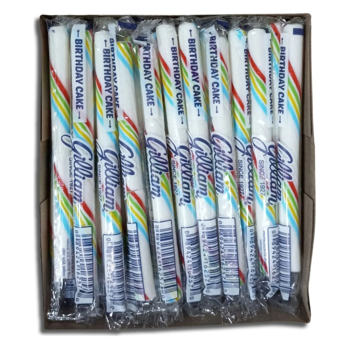 Open box of Gilliam Birthday Cake stick candy: rows of individually wrapped white sticks with rainbow stripes, wrappers printed Birthday Cake and UPC 0 89424 16257 0