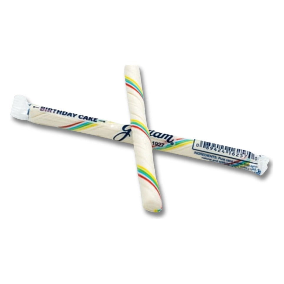 One Gilliam Birthday Cake candy stick, white with rainbow stripes, crossed over its wrapper printed Birthday Cake