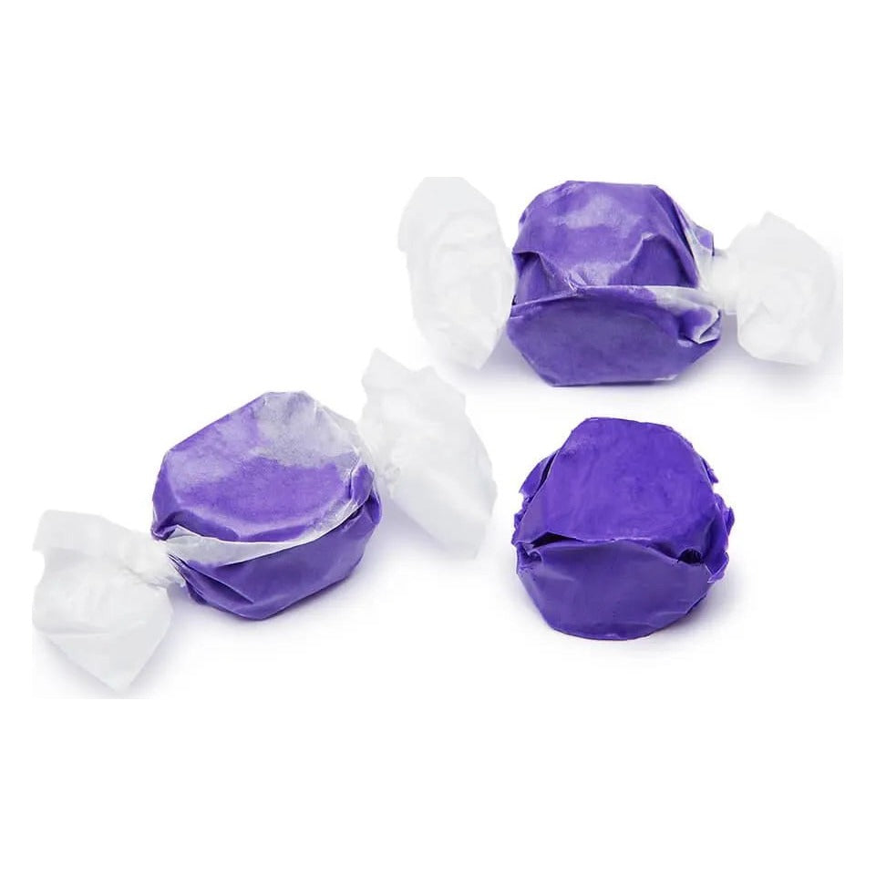Two wrapped and one unwrapped piece of purple Huckleberry salt water taffy