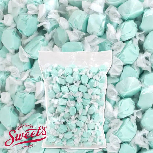 Clear bulk bag of wrapped light blue Sweet's Cotton Candy taffy over a close-up of the pieces with the Sweet's logo