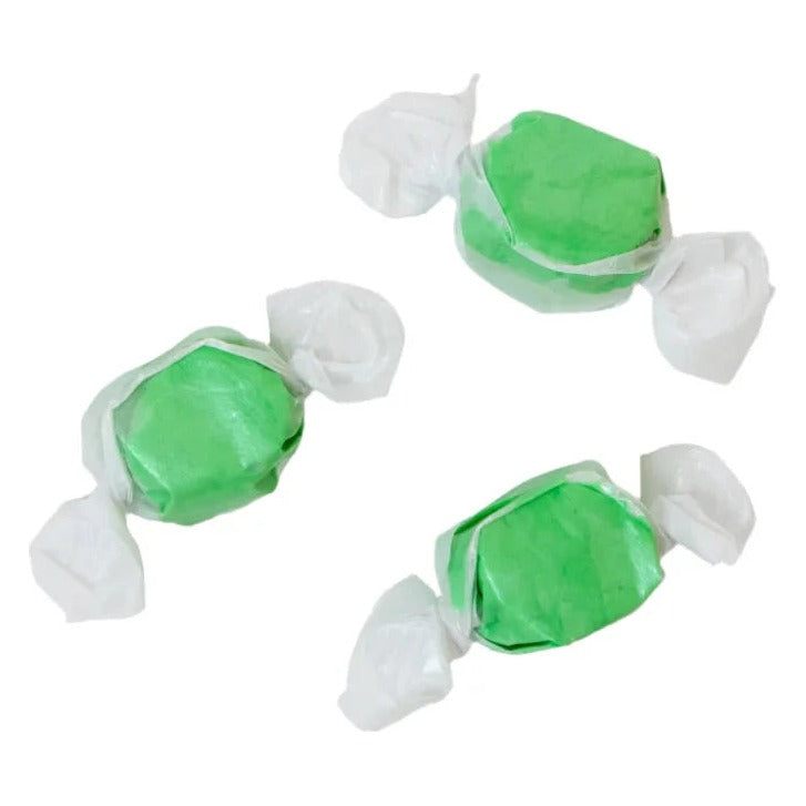 Three wrapped pieces of Sweet's Kiwi Coconut taffy in green on a white background