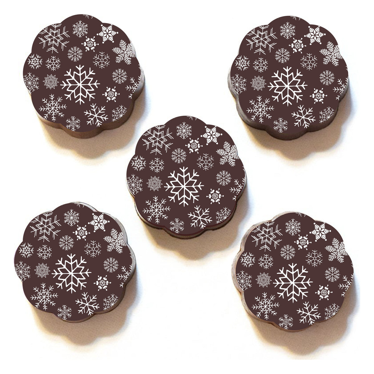 Five Chouquette Snowflake chocolate caramels on white, each top covered in small white snowflakes around a larger center flake