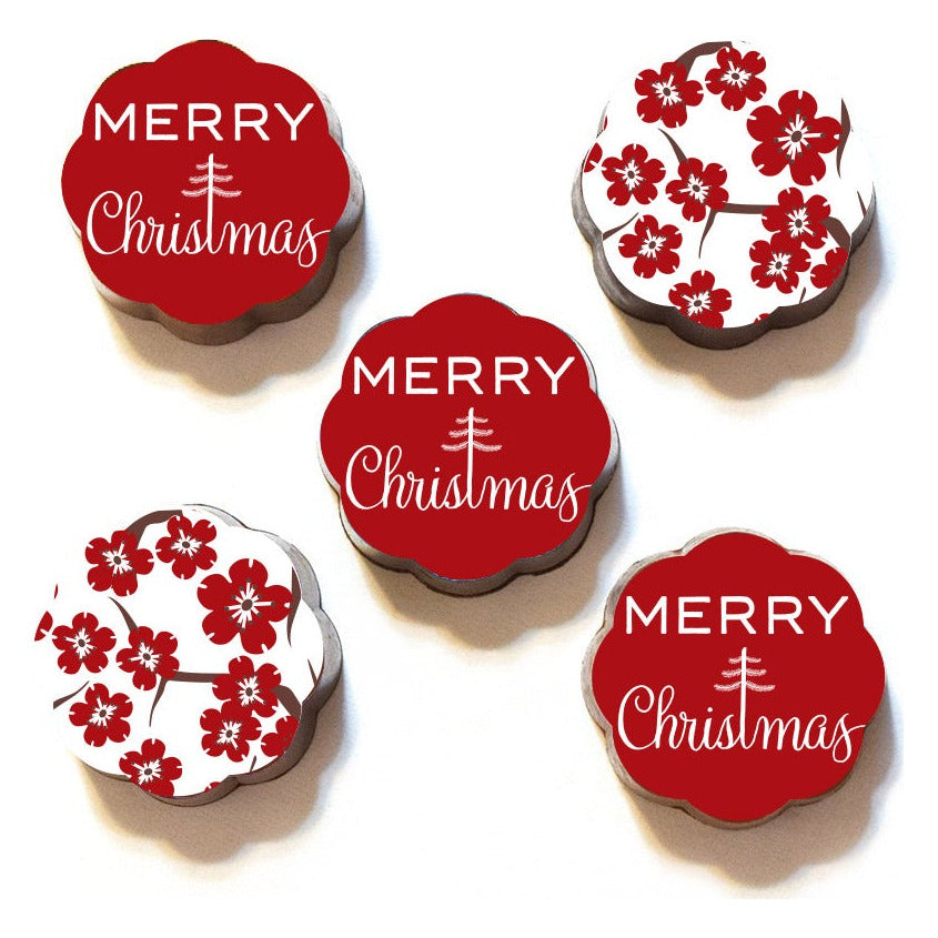 Five loose Chouquette Merry Christmas chocolate caramels: three red tops with white Merry Christmas lettering and two white tops with red blossoms
