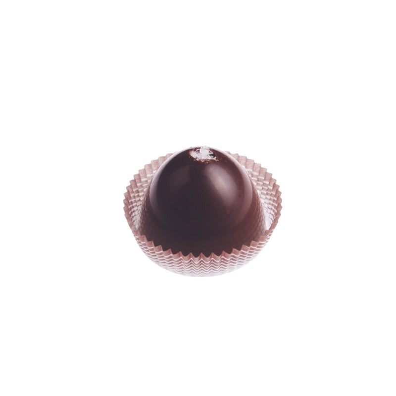 Ticket Chocolate petite Sea Salt Caramel truffle: a glossy semi-sweet chocolate dome topped with sea salt flakes, sitting in a pleated paper candy cup