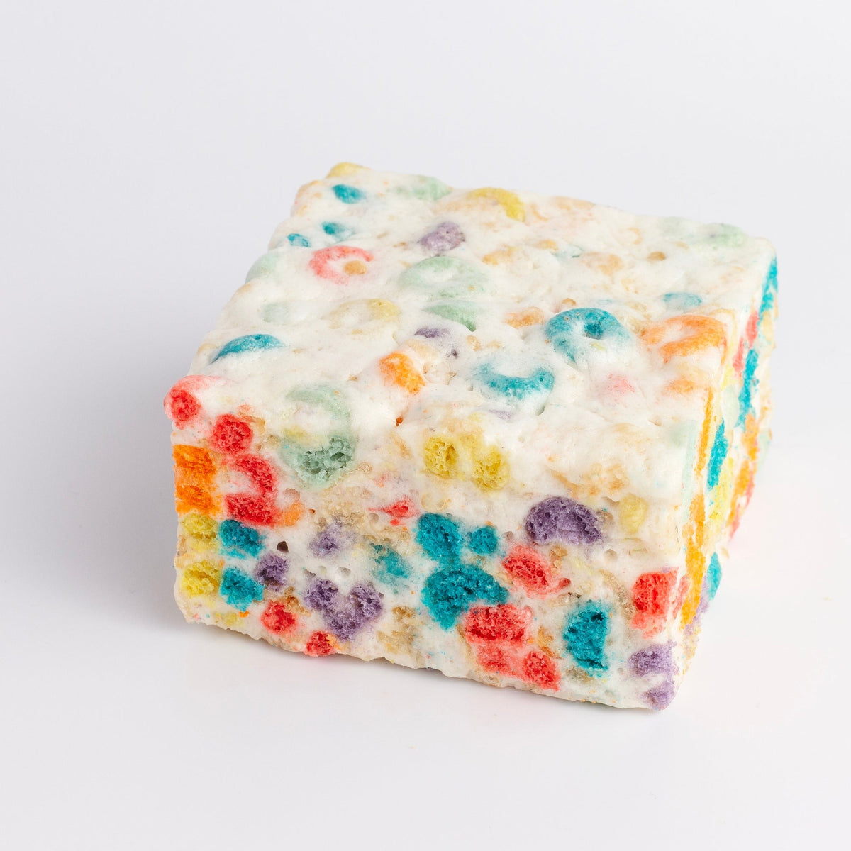 The Crispery Fruity Ringlets Crispycake: marshmallow crispy rice square with red, orange, yellow, green, blue and purple fruity cereal rings on every side