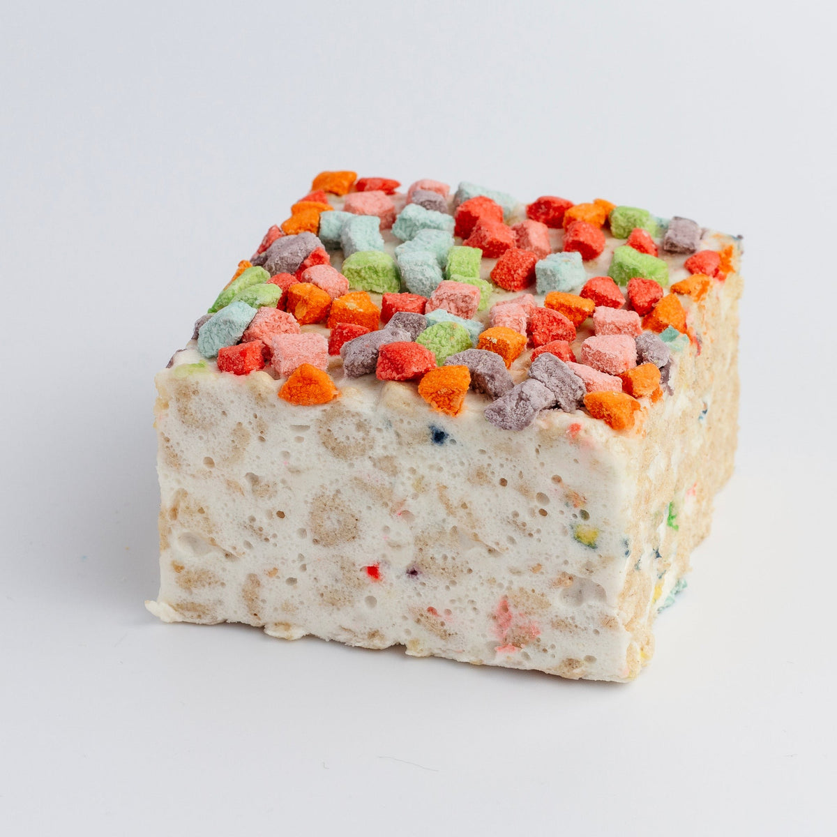 The Crispery Magical Charms Crispycake: marshmallow crispy rice square topped with pink, orange, green, blue and purple charm-shaped marshmallows