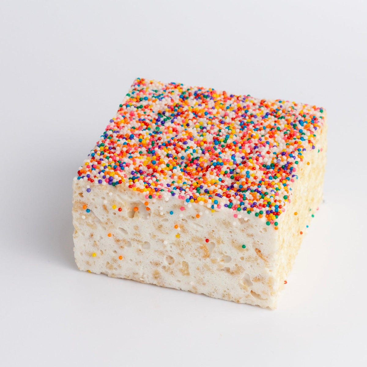 Rainbow Nonpareils Crispycake on a white background, top fully covered in tiny multicolored nonpareils