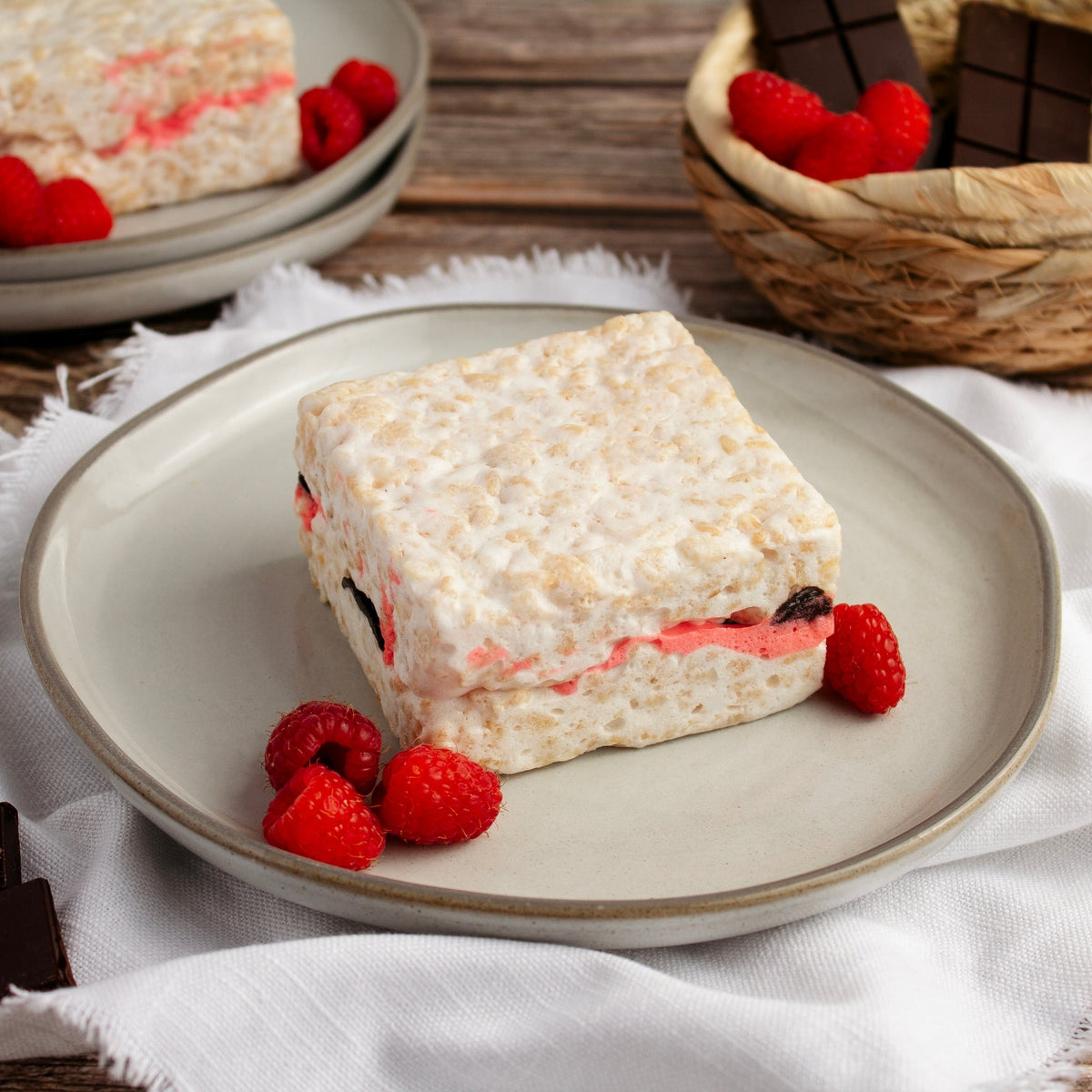Raspberry Chocolate Crispycake on a gray plate with fresh raspberries on a white cloth