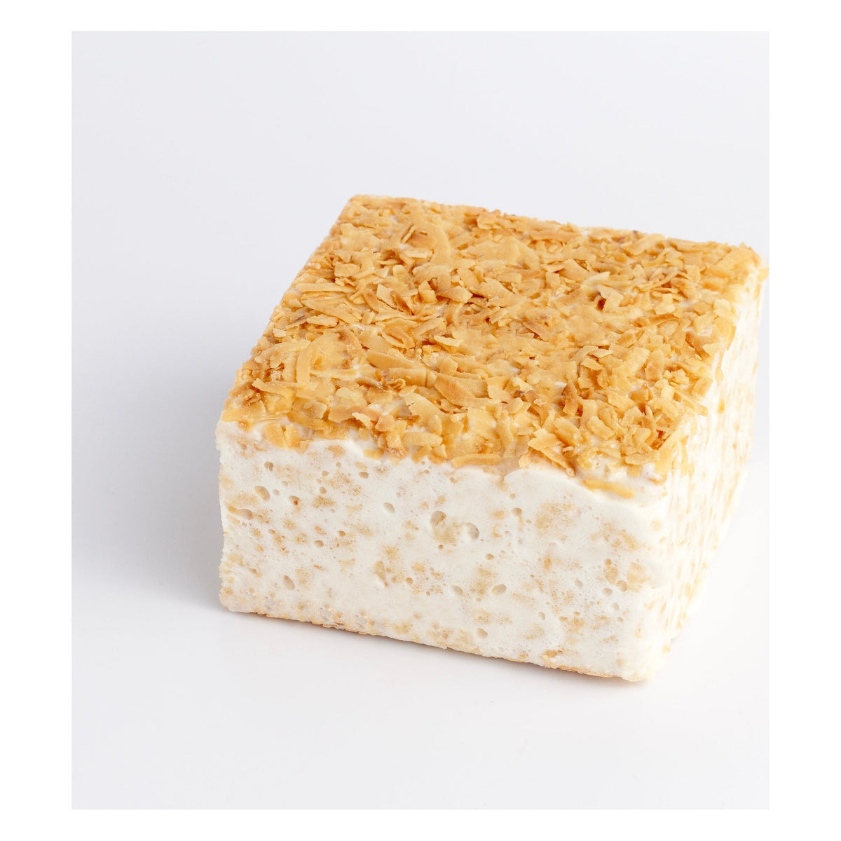 Toasted Coconut Crispycake on a white background, top covered in golden toasted coconut flakes