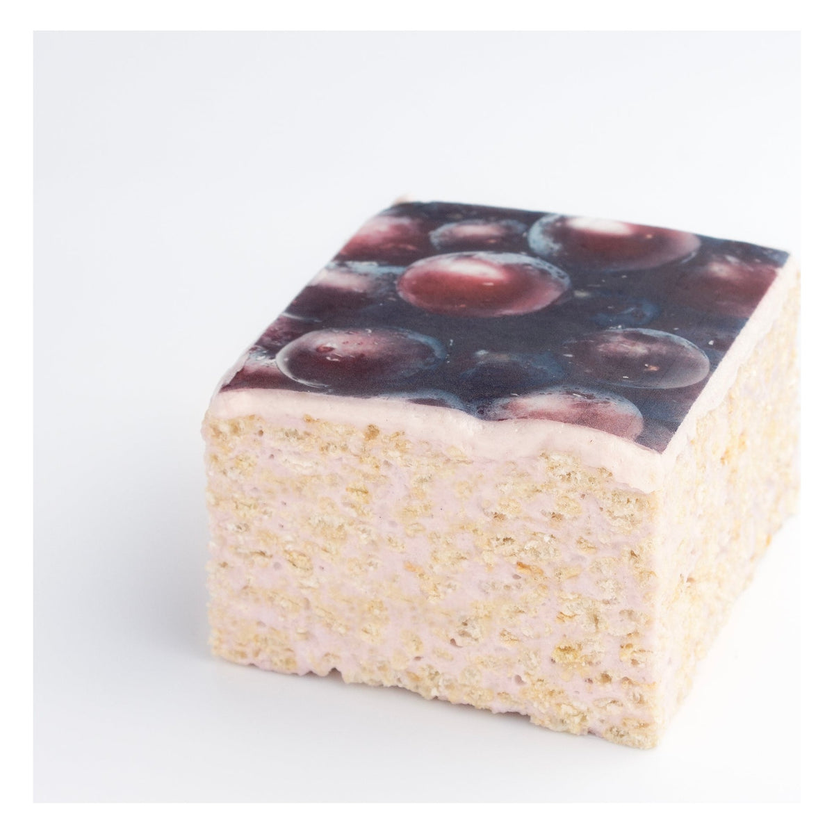The Crispery Tropical Fruit Grape Crispycake on a grey background, with printed purple grapes on top and crispy rice sides