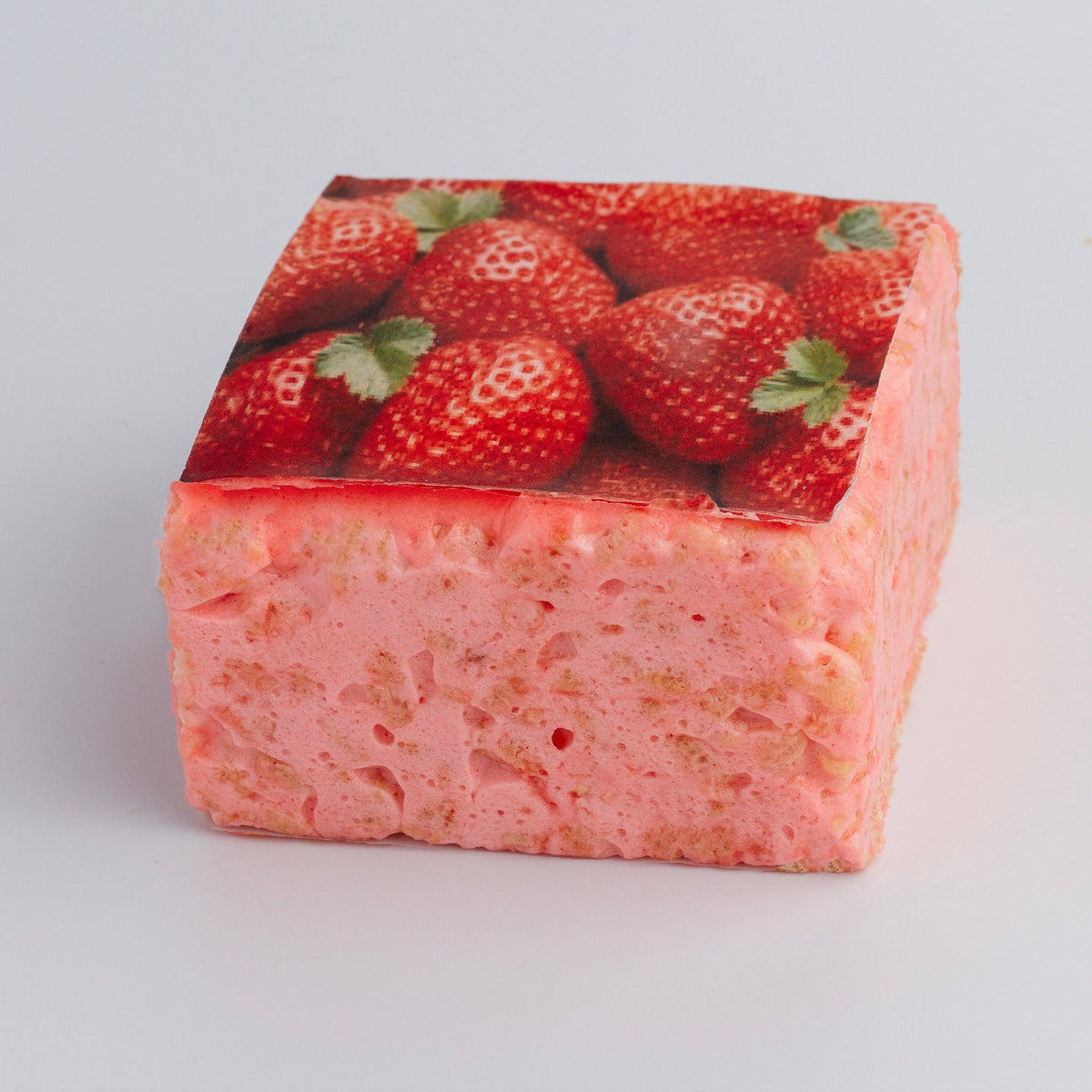 The Crispery Tropical Fruit Strawberry Crispycake on a grey background, with printed red strawberries on top