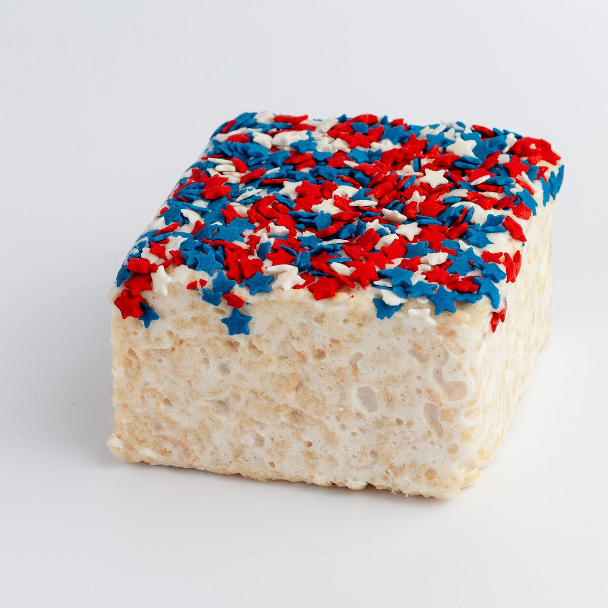 The Crispery USA Sprinkles Crispycake on a grey background, topped with red, white and blue sprinkles and stars