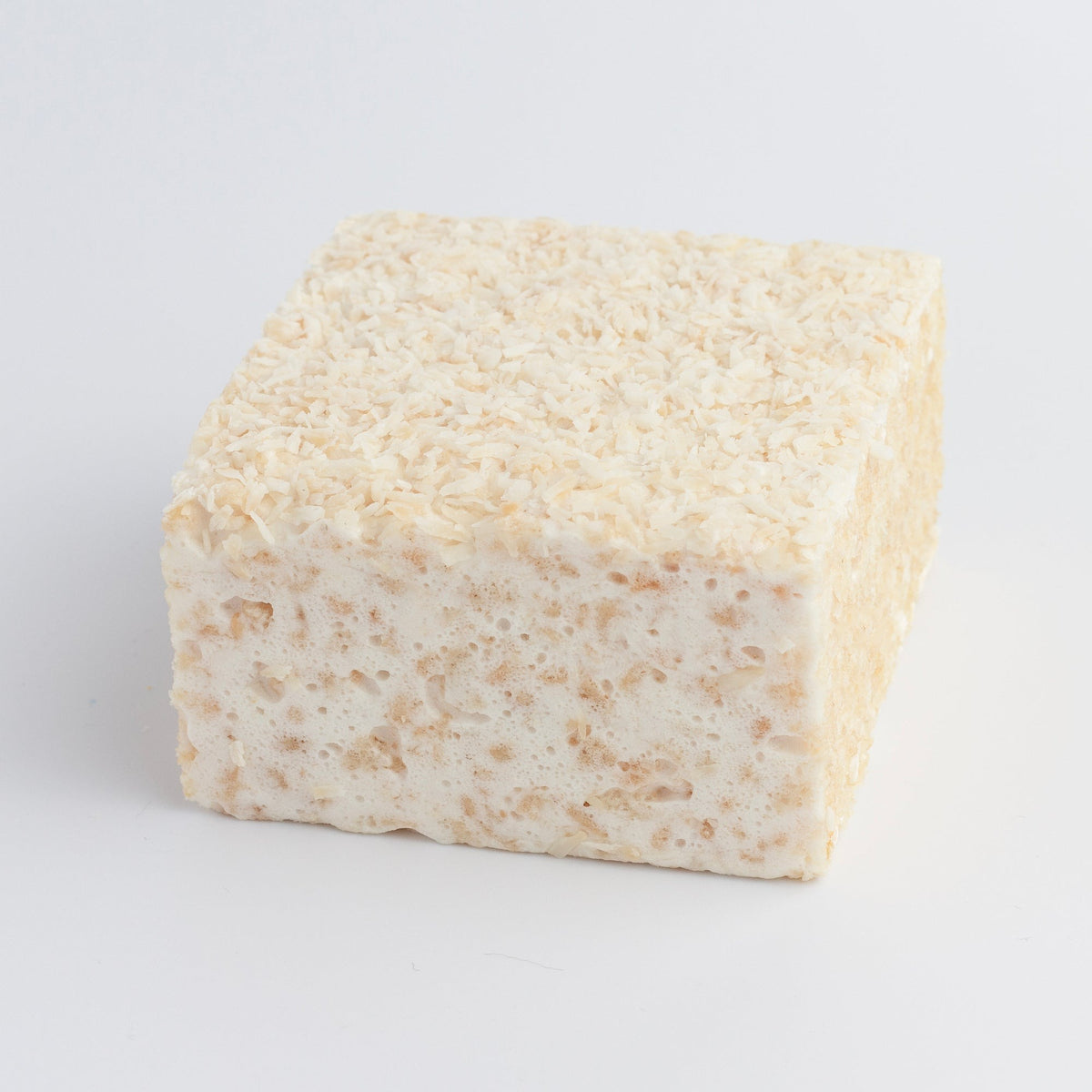 The Crispery White Coconut Crispycake on a light grey background, its top covered in shredded coconut