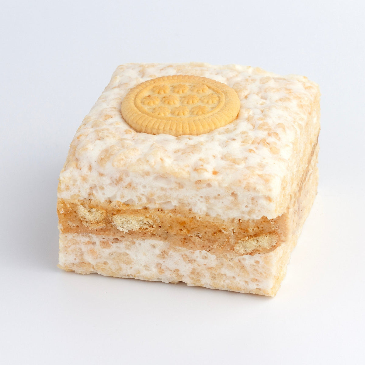 The Crispery Peanut Butter Cookies Crispycake on a grey background, with a whole cookie on top and a crushed-cookie layer through the middle