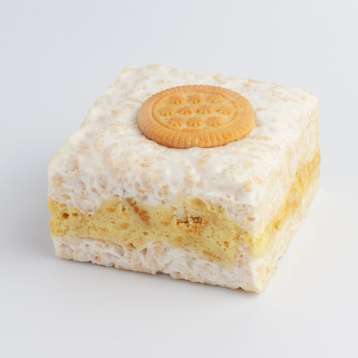 Lemon Cookies & Cream Crispycake on a light gray background showing the yellow lemon cream layer and a round lemon cookie on top