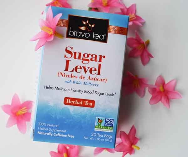 Bravo Sugar Level Herbal Tea box with white mulberry, lying among pink flowers