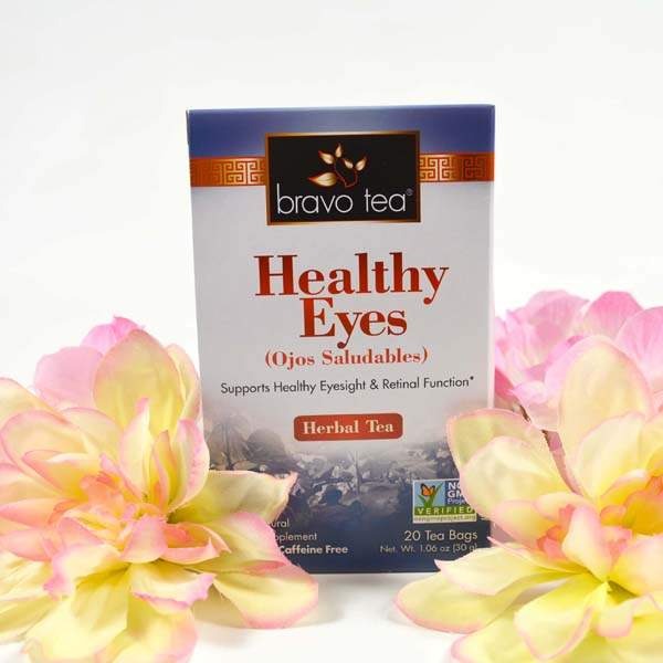 Bravo Healthy Eyes Herbal Tea box standing between pink and yellow flowers