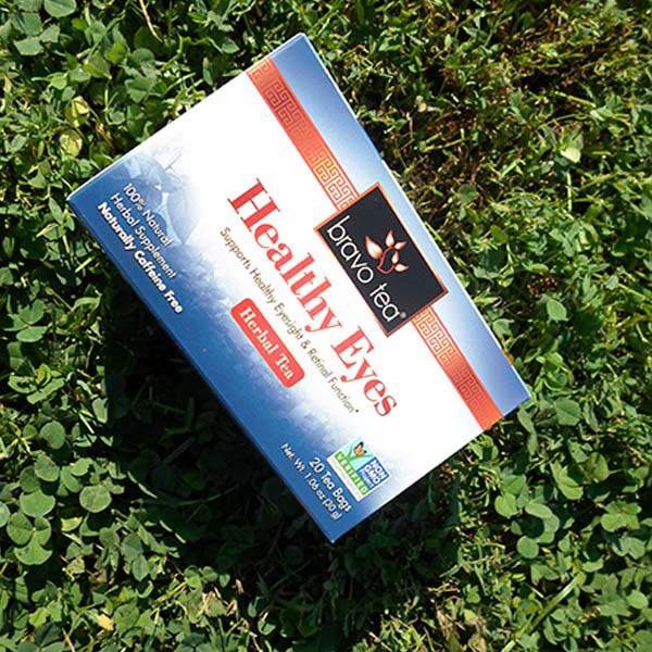 Bravo Healthy Eyes Herbal Tea box lying on green clover