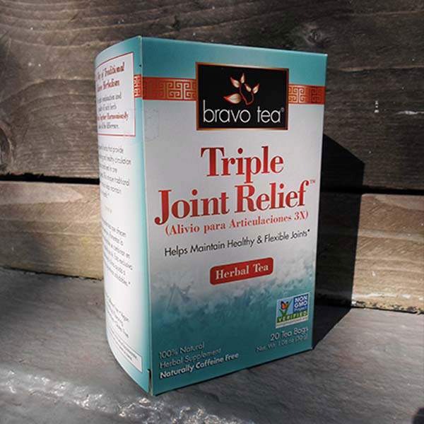 Bravo Triple Joint Relief Herbal Tea box on a weathered wooden bench with the side panel visible