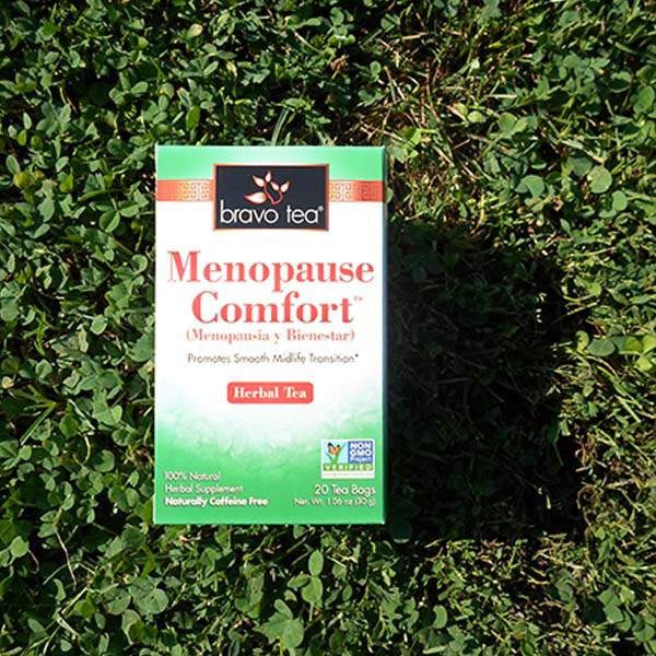 Bravo Tea Menopause Comfort herbal tea box resting on green clover