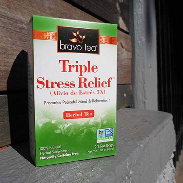 Bravo Tea Triple Stress Relief box standing on a stone ledge beside a wooden post