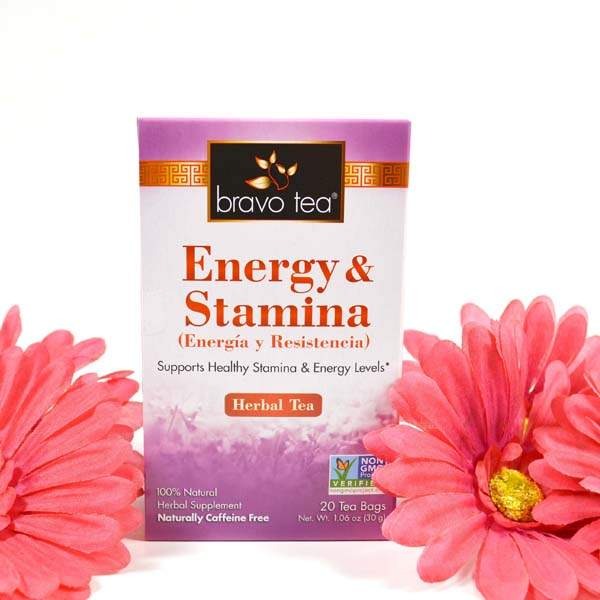 Bravo Tea Energy & Stamina box standing between coral gerbera daisies