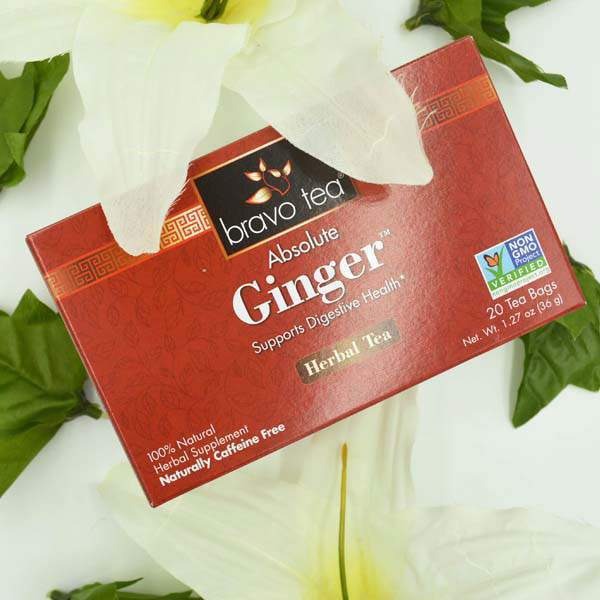 Bravo Tea Absolute Ginger box lying on its side among white lilies and green leaves