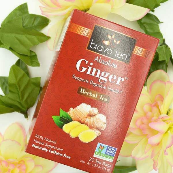 Bravo Tea Absolute Ginger box resting on pale yellow flowers, front showing the ginger illustration