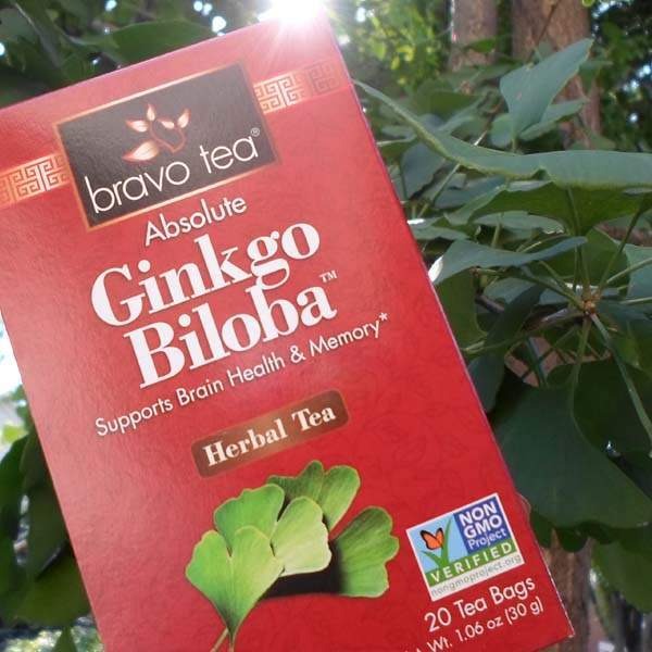 Bravo Tea Absolute Ginkgo Biloba box held up against tree branches in sunlight