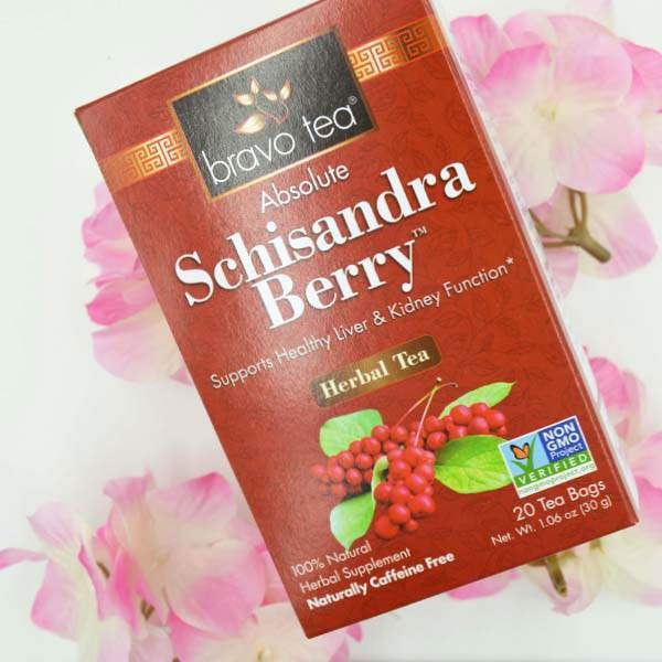 Bravo Tea Absolute Schisandra Berry box laid on a white surface beside pink flowers