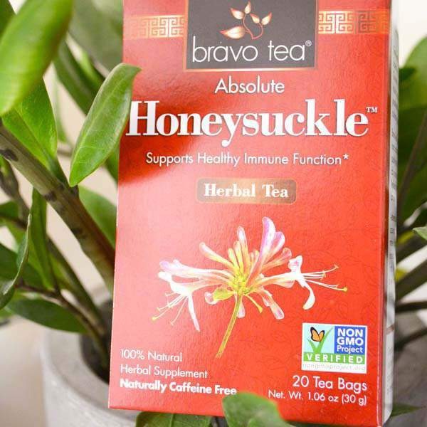 Bravo Tea Absolute Honeysuckle box standing in front of a green potted plant
