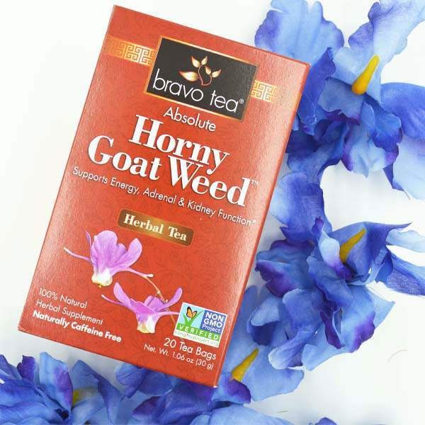 Bravo Tea Absolute Horny Goat Weed box laid on a white surface beside blue irises