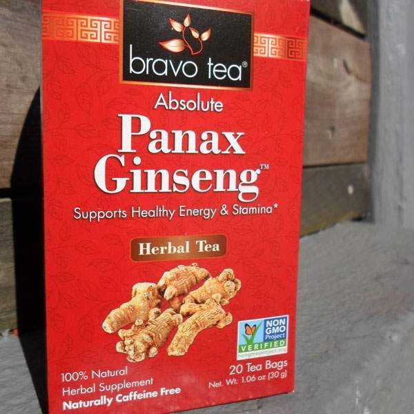 Bravo Tea Absolute Panax Ginseng box upright against weathered wood, front panel with ginseng root artwork