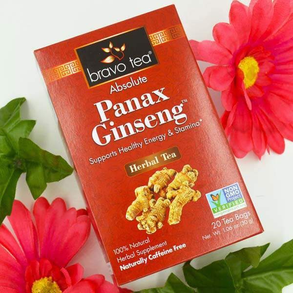 Bravo Tea Absolute Panax Ginseng box laid on a white surface beside red flowers
