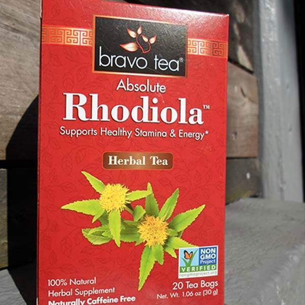 Bravo Tea Absolute Rhodiola box upright against weathered wood, front panel with yellow rhodiola flower artwork