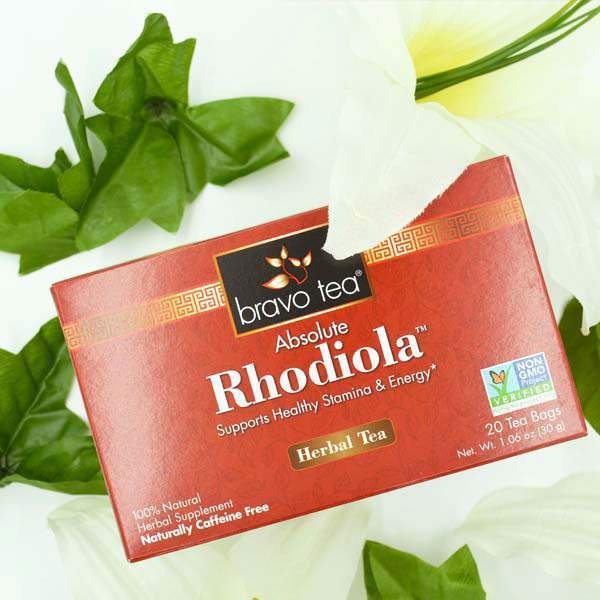 Bravo Tea Absolute Rhodiola box on its side among white lilies with a tea bag envelope at the top