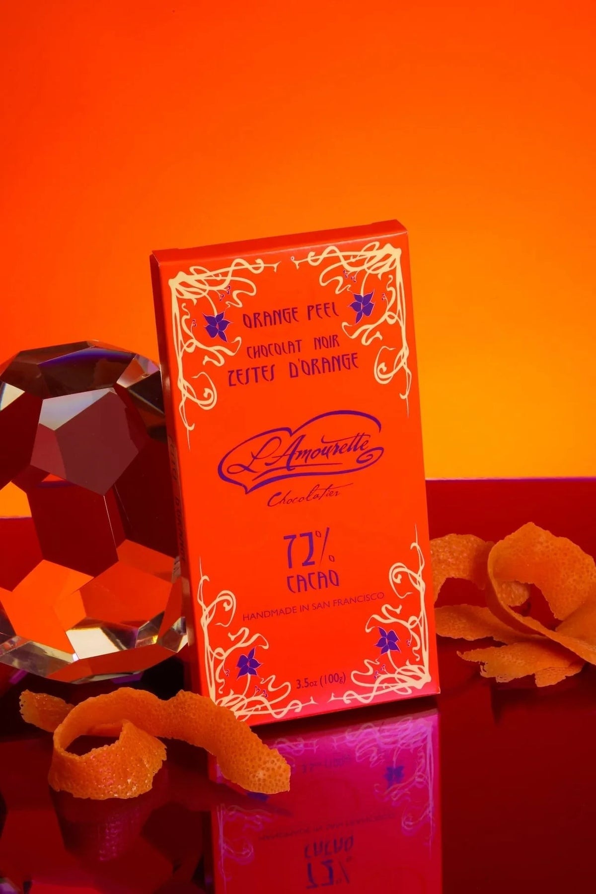 L'Amourette Chocolat 72% Dark Chocolate with Candied Orange Peel Bar styled on a table