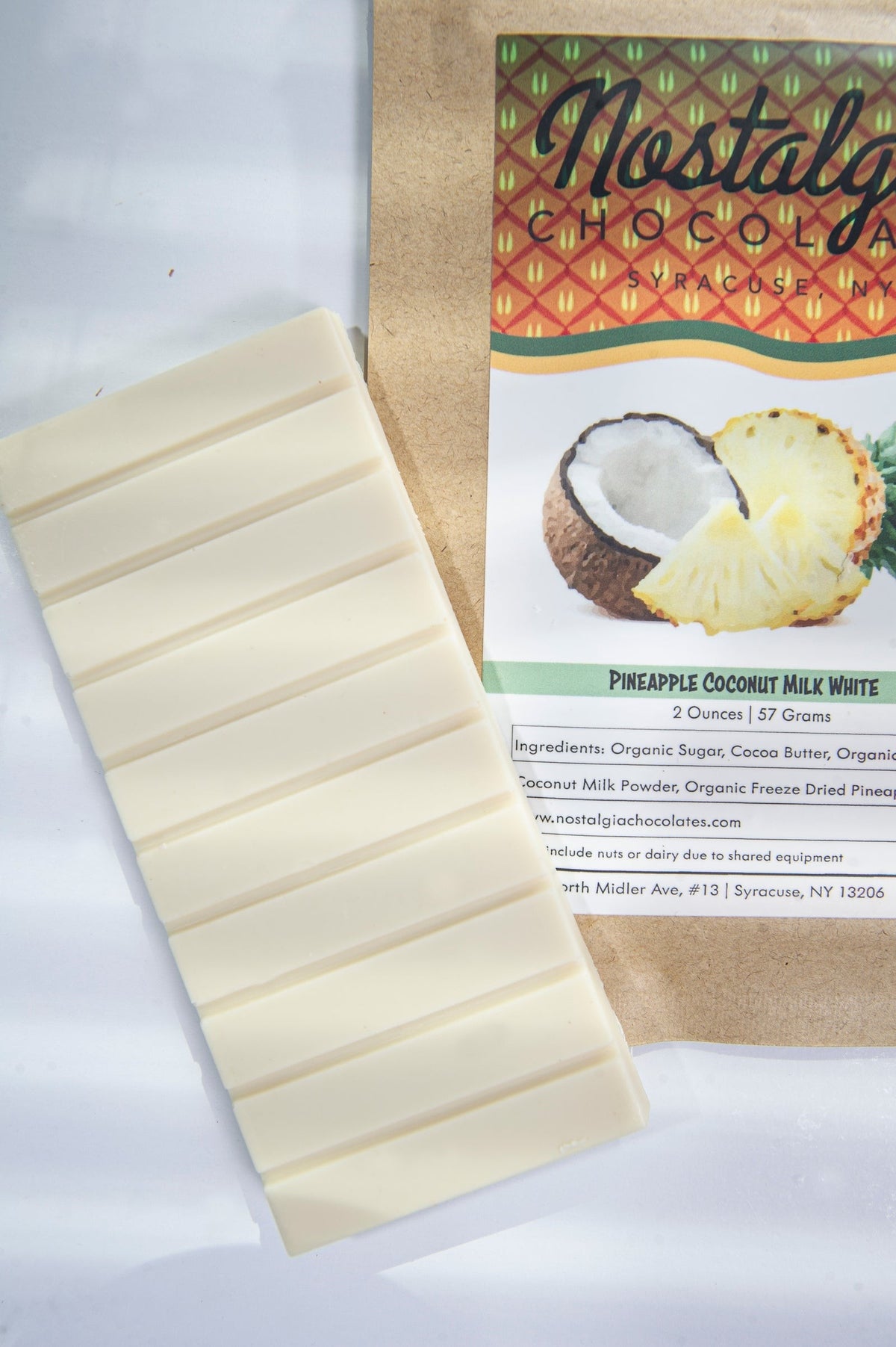 Close-up of Nostalgia Chocolates Pineapple Coconut Milk White Chocolate Bar as it comes out of the package